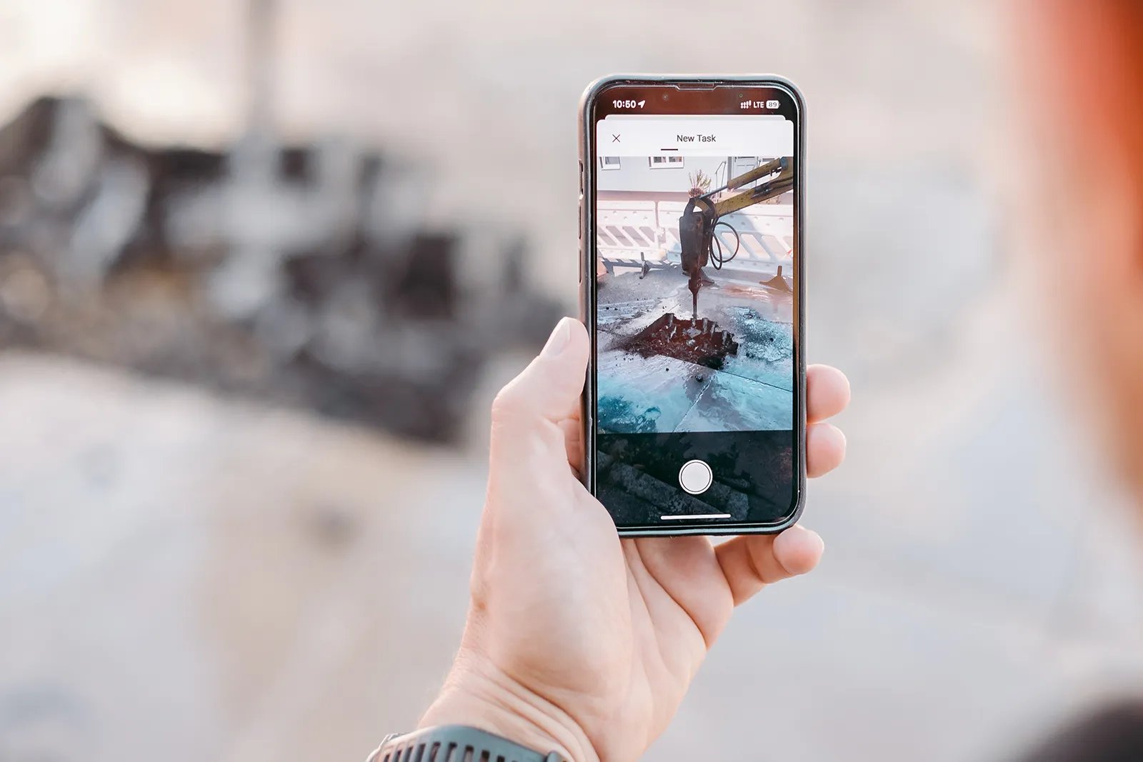 vialytics to do app in the hand of a person taking a picture of an excavation site